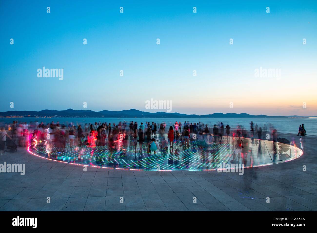 People gather on the magnificent monument to the sun at dusk, Zadar, Zadar, Croatia, Europe Stock Photo