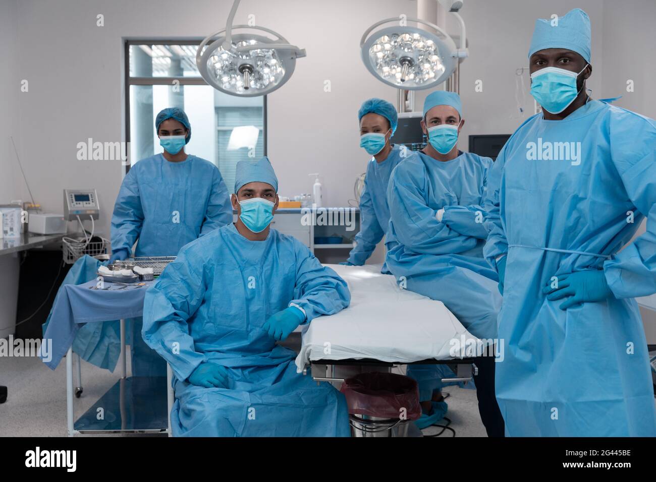 Diverse surgeons wearing face masks and protective clothing in