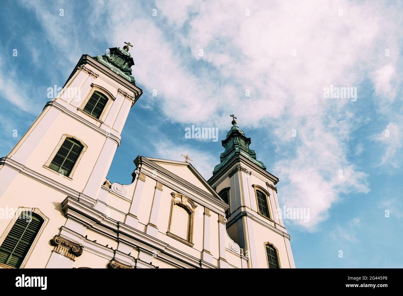 Spiers of a beautiful ancient temple in Budapest against a blue sky with white clouds Stock Photo