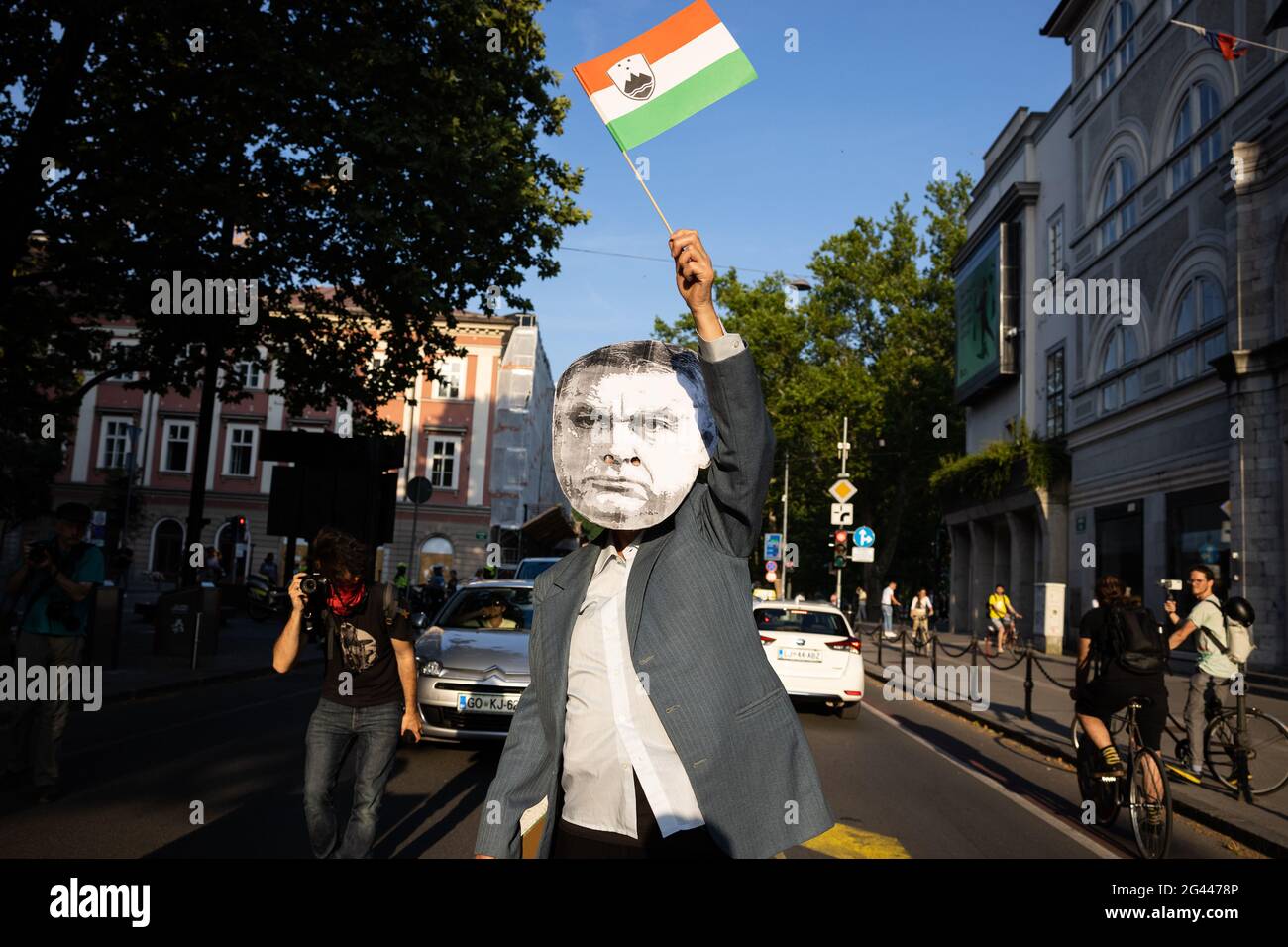 A protester wearing a mask with the face of Hungarian Prime Minister Viktor  Orban waves a fake combined Slovenian Hungarian flag in the street in  Ljubljana during an anti-government protest.The Friday anti-government