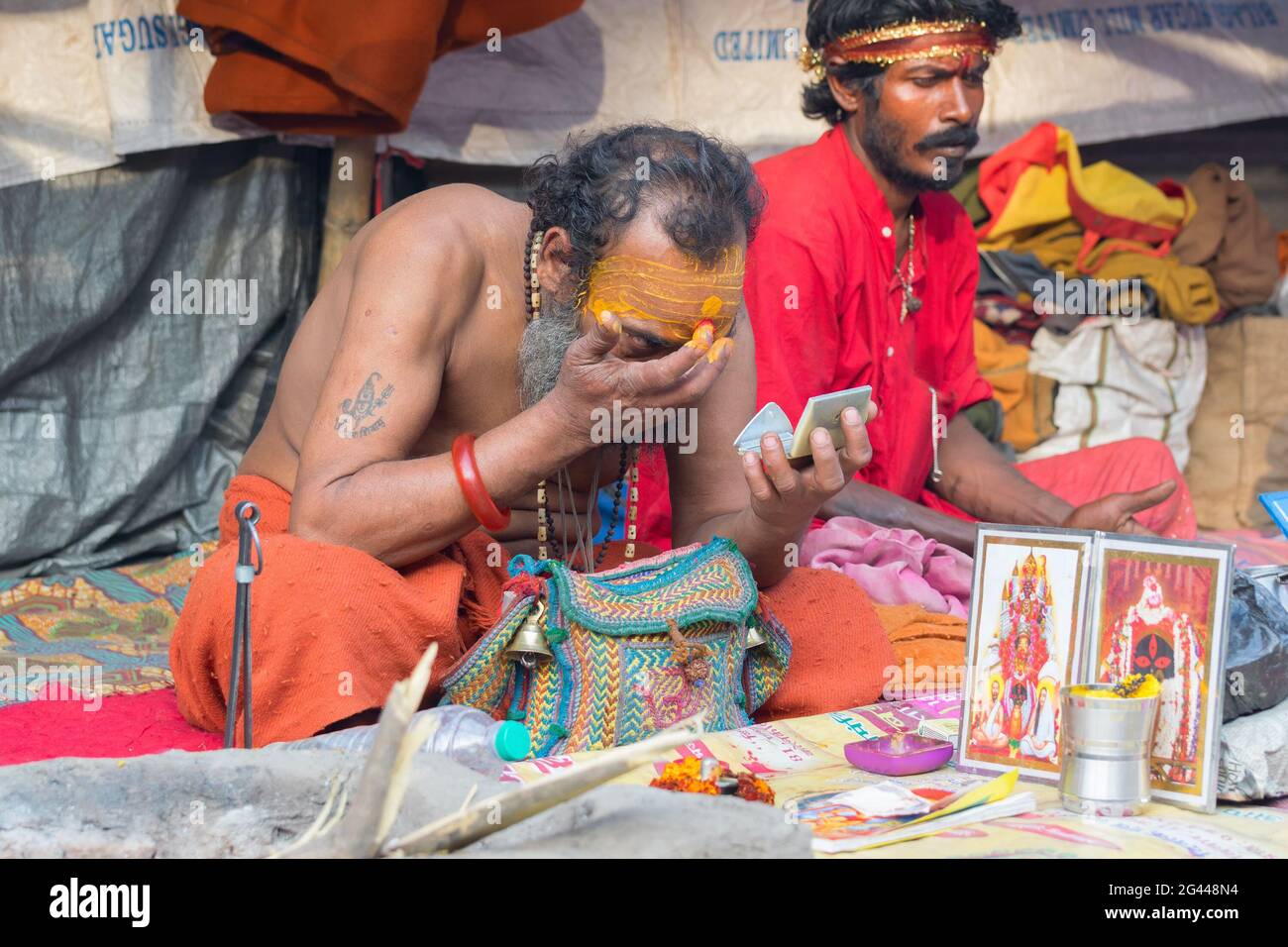 BABUGHAT, KOLKATA, WEST BENGAL / INDIA - 10TH JANUARY 2015 : Hindu Sadhu making up for rituals , wearing bindi, a big red dot on forehead. Stock Photo
