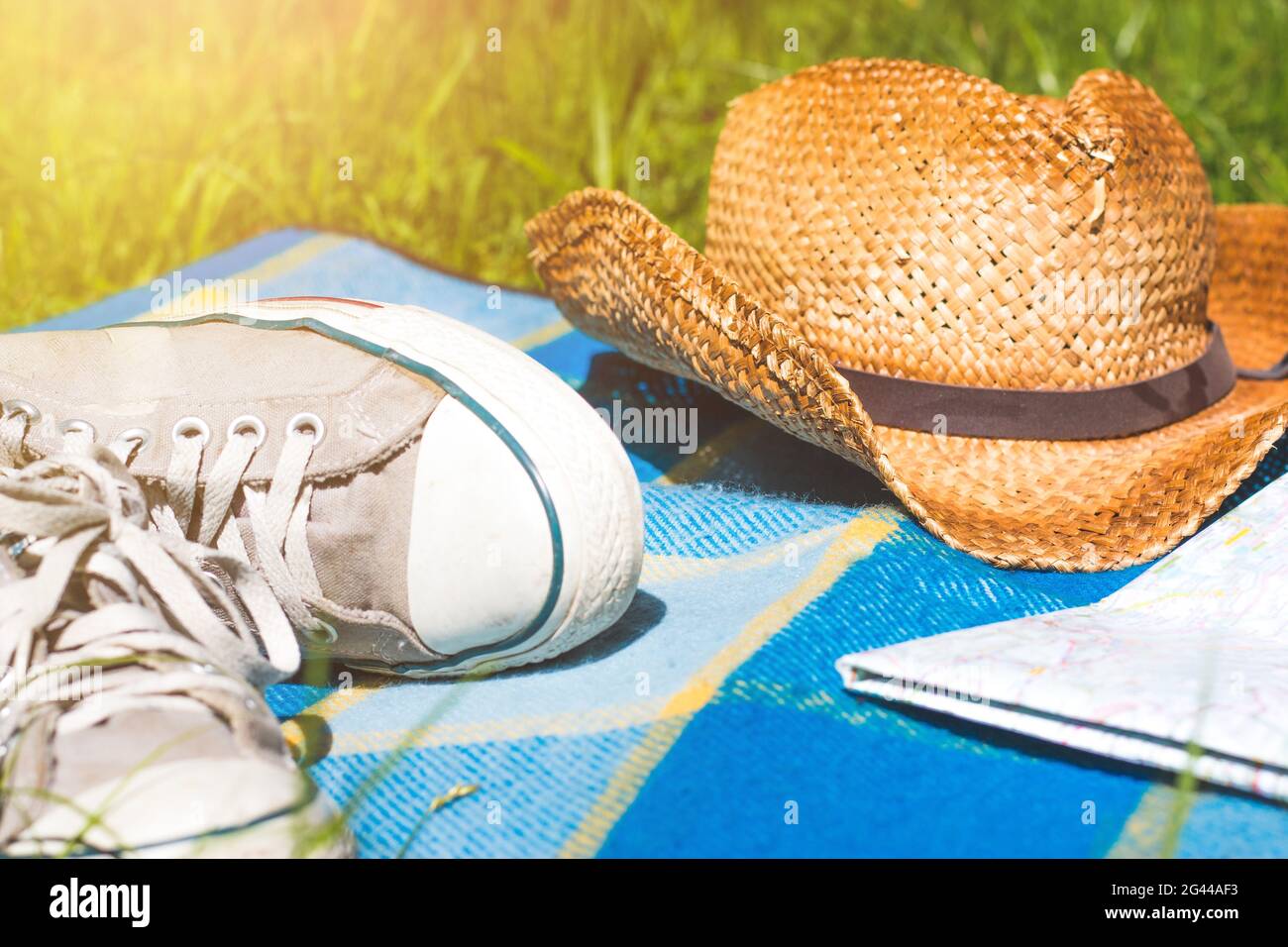 Chilling in the summer concept picnic blanket with sneakers, map and