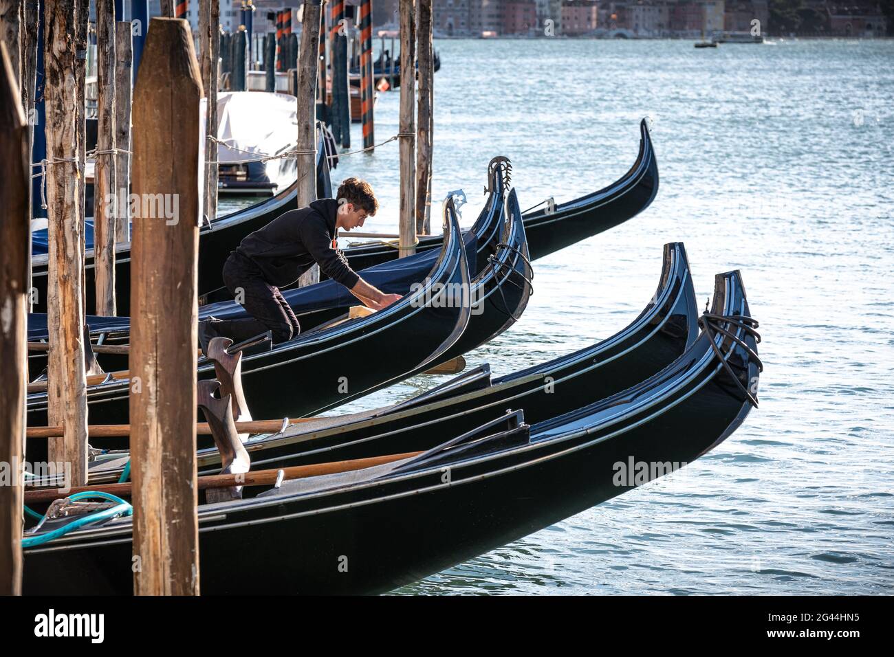View of a gondolier cleaning his gondola on the Grand Canal, Venice, Veneto, Italy, Europe Stock Photo