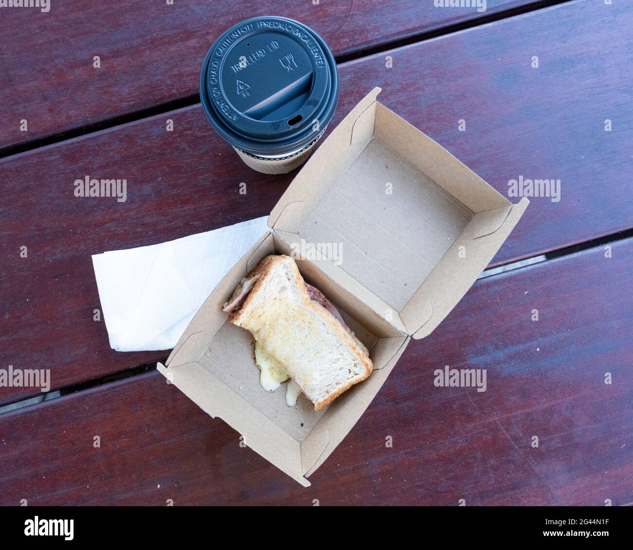 Takeaway toasted ham and cheese sandwich and coffee. Stock Photo