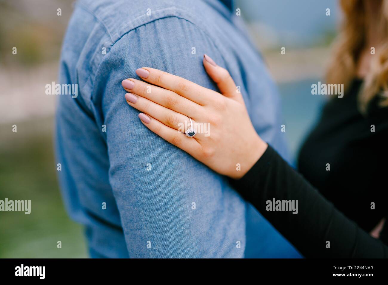 Girl put her hand with a ring on the man's shoulder. Close up Stock Photo