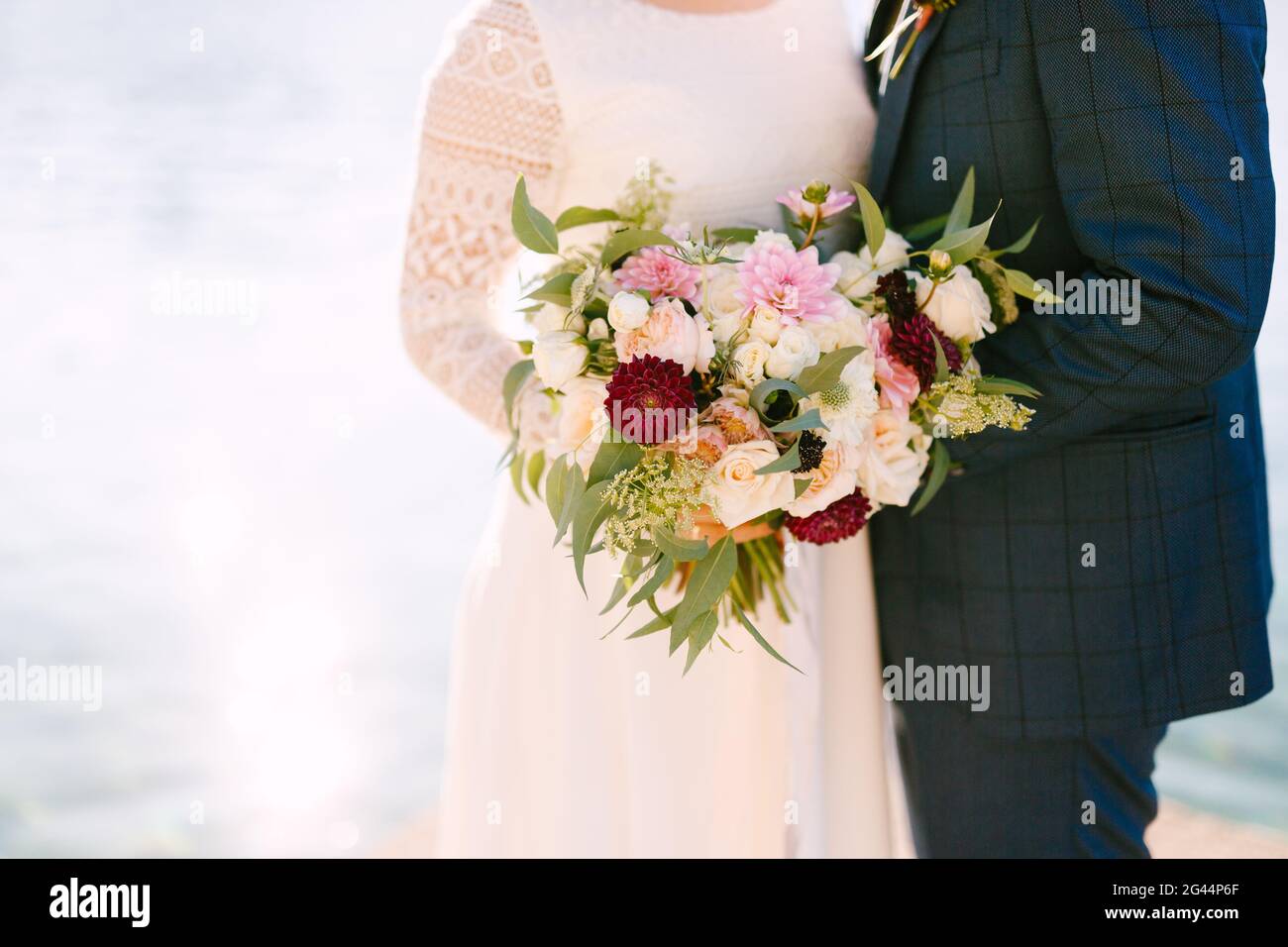 Bride and groom holding a beautiful bouquet of flowers Stock Photo