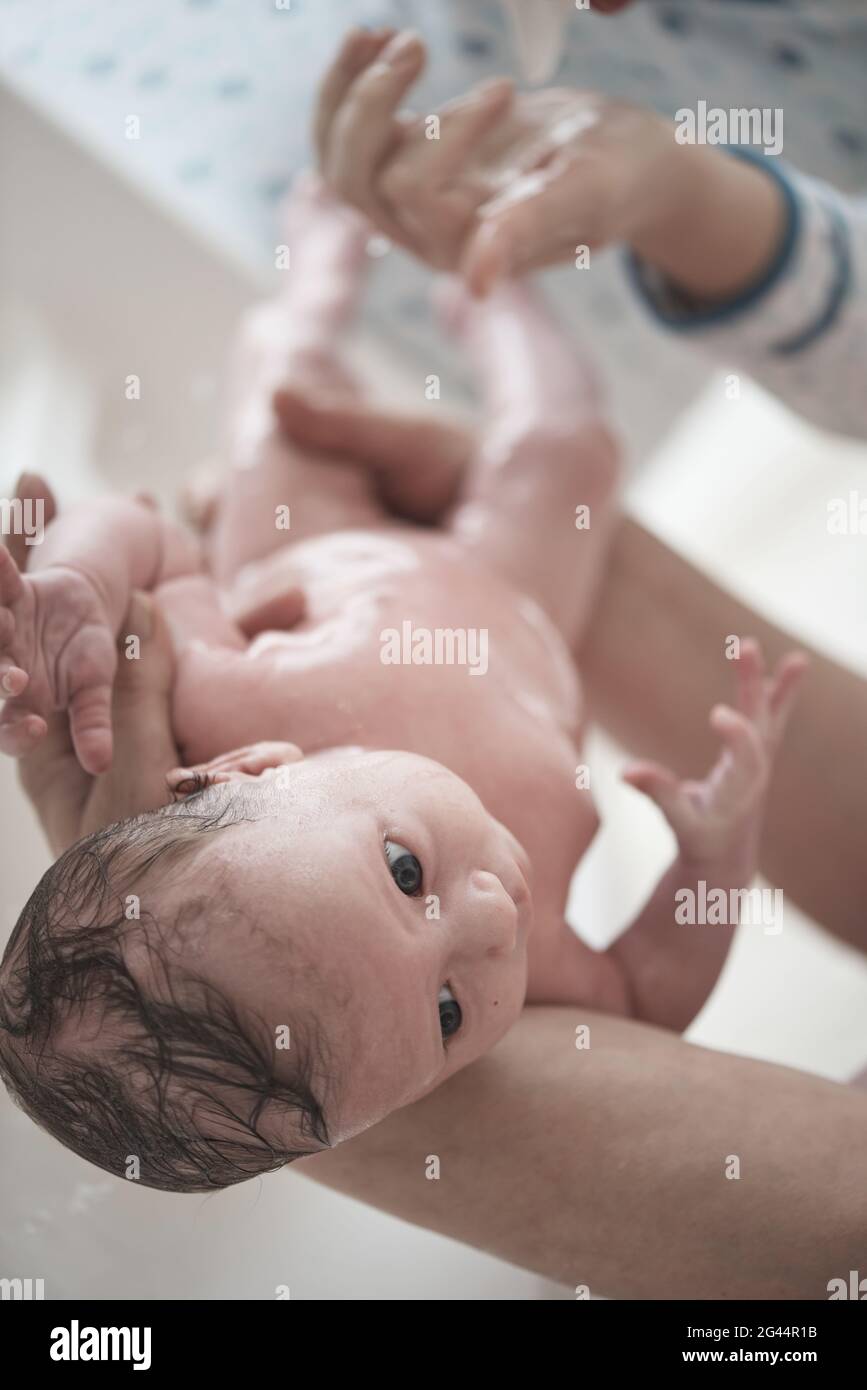 Newborn baby girl taking a bath Stock Photo