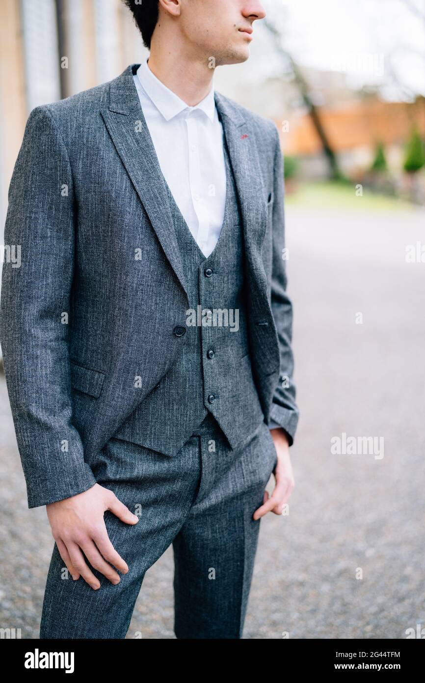 Serious groom looks into the distance against the background of old buildings. Lake Como Stock Photo