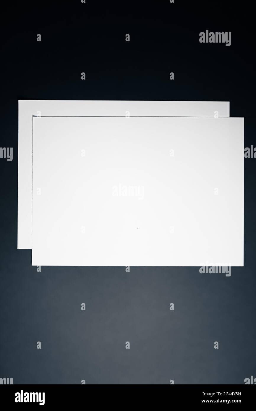 Blank A4 paper, white on black background as office stationery flatlay