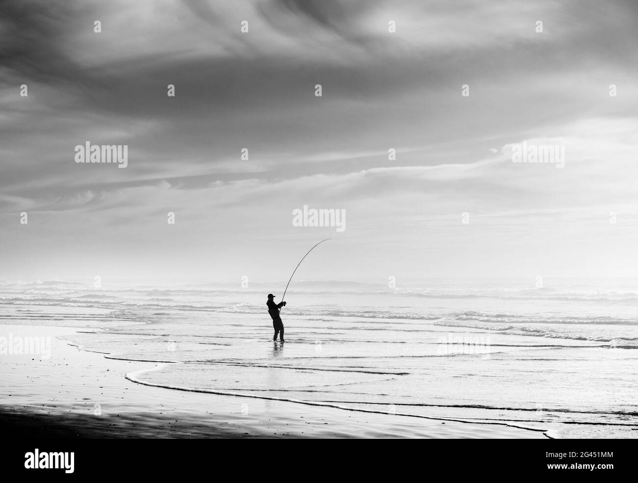 Silhouette of fisherman fishing on beach in black and white Stock Photo ...