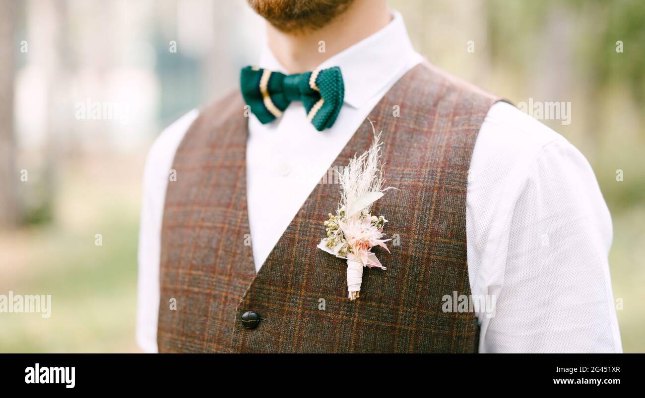 Half-length portrait of groom in white shirt green bow-tie and brown vest Stock Photo