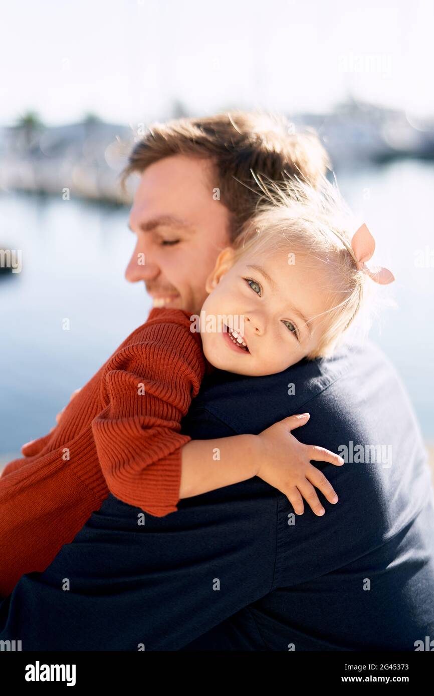 Father and daughter are hugging during their walk by the sea Stock Photo