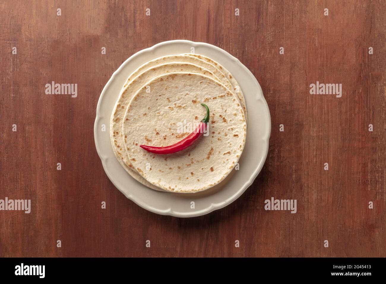 A red chili pepper, shot from above on a pile of tortillas, Mexican