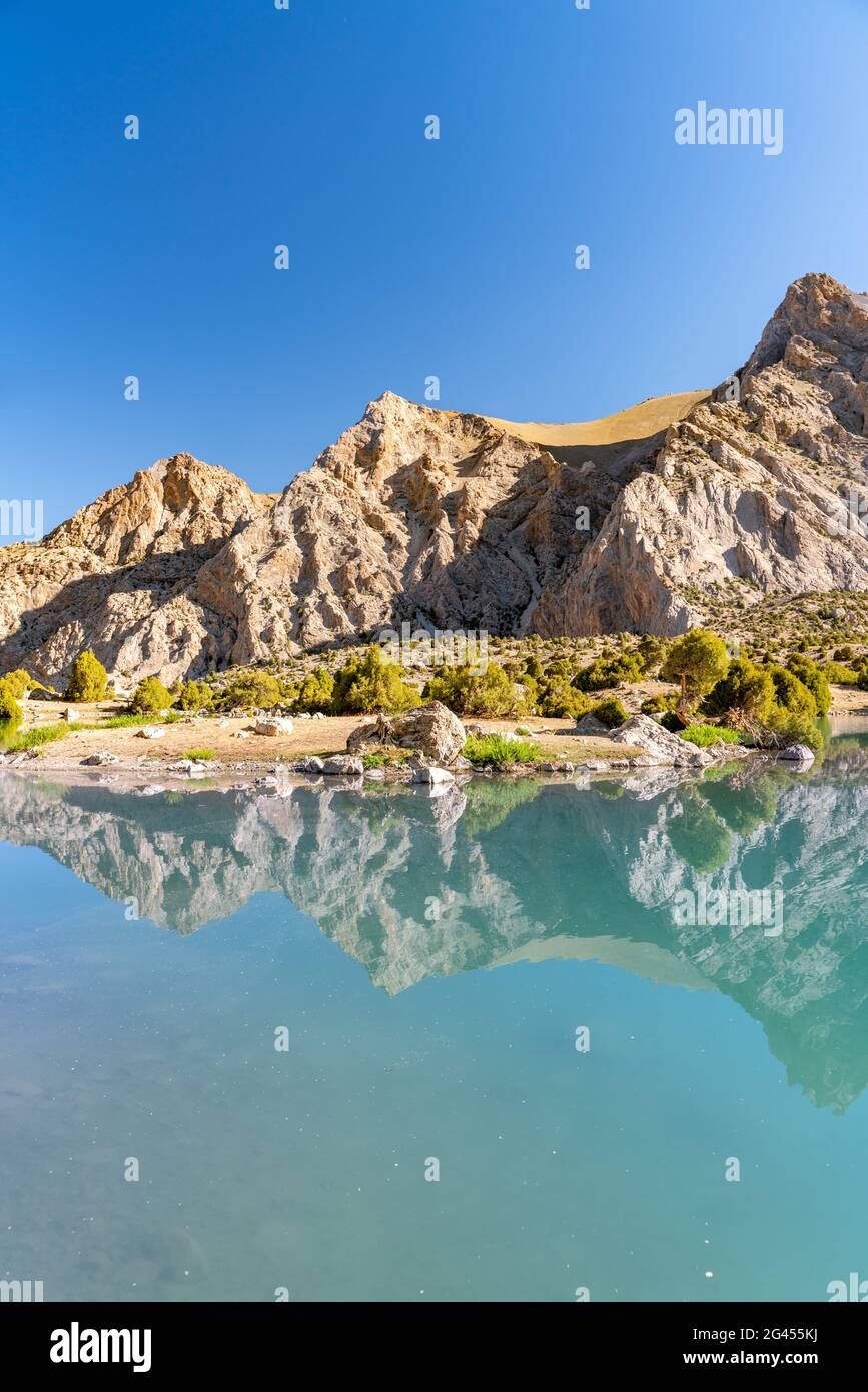 The Pamir range view and peaceful campsite on Kulikalon lake in Fann mountains in Tajikistan. Amasing colorful reflection in pur Stock Photo