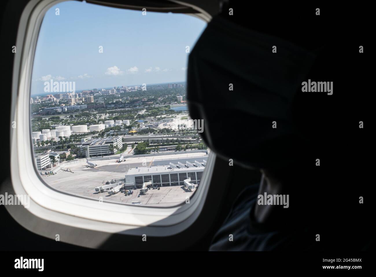 A passenger wears a protective face mask against COVID-19 as a view of grounded planes at Miami International Airport as the Colombian government sponsored free repatriation flights back to Colombia admist the novel Coronavirus (COVID-19) outbreak and the result of commercial flights grounded, in Miami, Florida, U.S, on August 7, 2020. Stock Photo