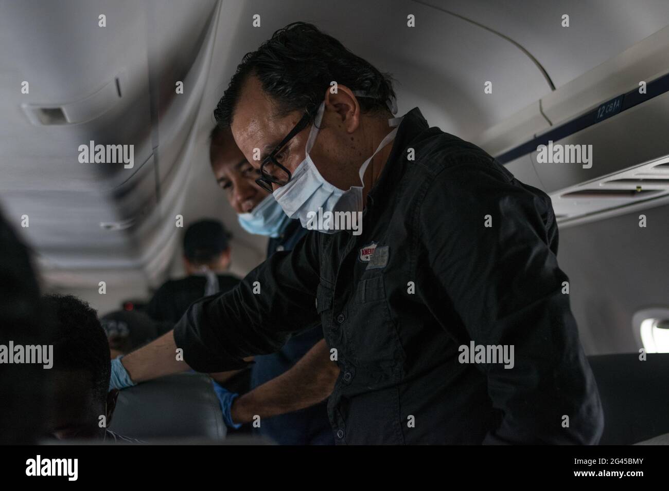 People wearing face masks to prevent Coronavirus transmission prepare to leave the flight as the Colombian government sponsored free repatriation flights back to Colombia admist the novel Coronavirus (COVID-19) outbreak and the result of commercial flights grounded, in Miami, Florida, U.S, on August 7, 2020. Stock Photo