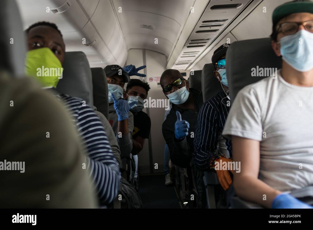 A group of men pose for a photo while using surgical gloves and face masks against COVID-19 as the Colombian government sponsored free repatriation flights back to Colombia admist the novel Coronavirus (COVID-19) outbreak and the result of commercial flights grounded, in Miami, Florida, U.S, on August 7, 2020. Stock Photo