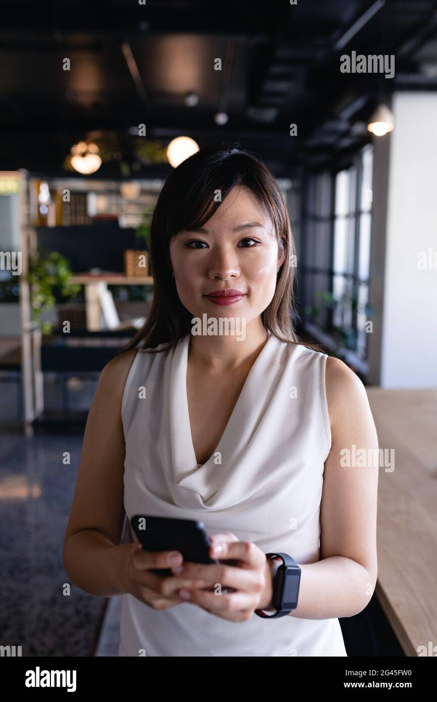 Asian woman using her phone and wearing digital watch Stock Photo Alamy