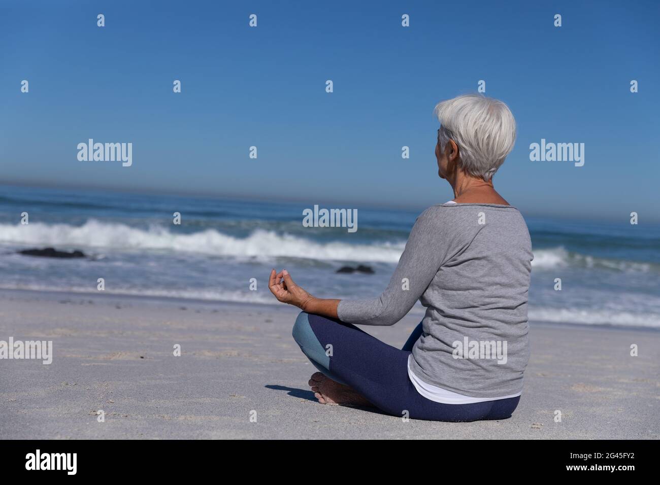 Senior Caucasian woman meditating at the beach Stock Photo - Alamy