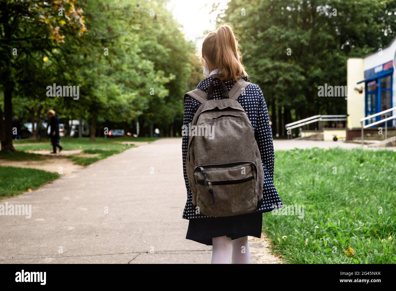 Back to school education concept. Little girl carrying backpacks going