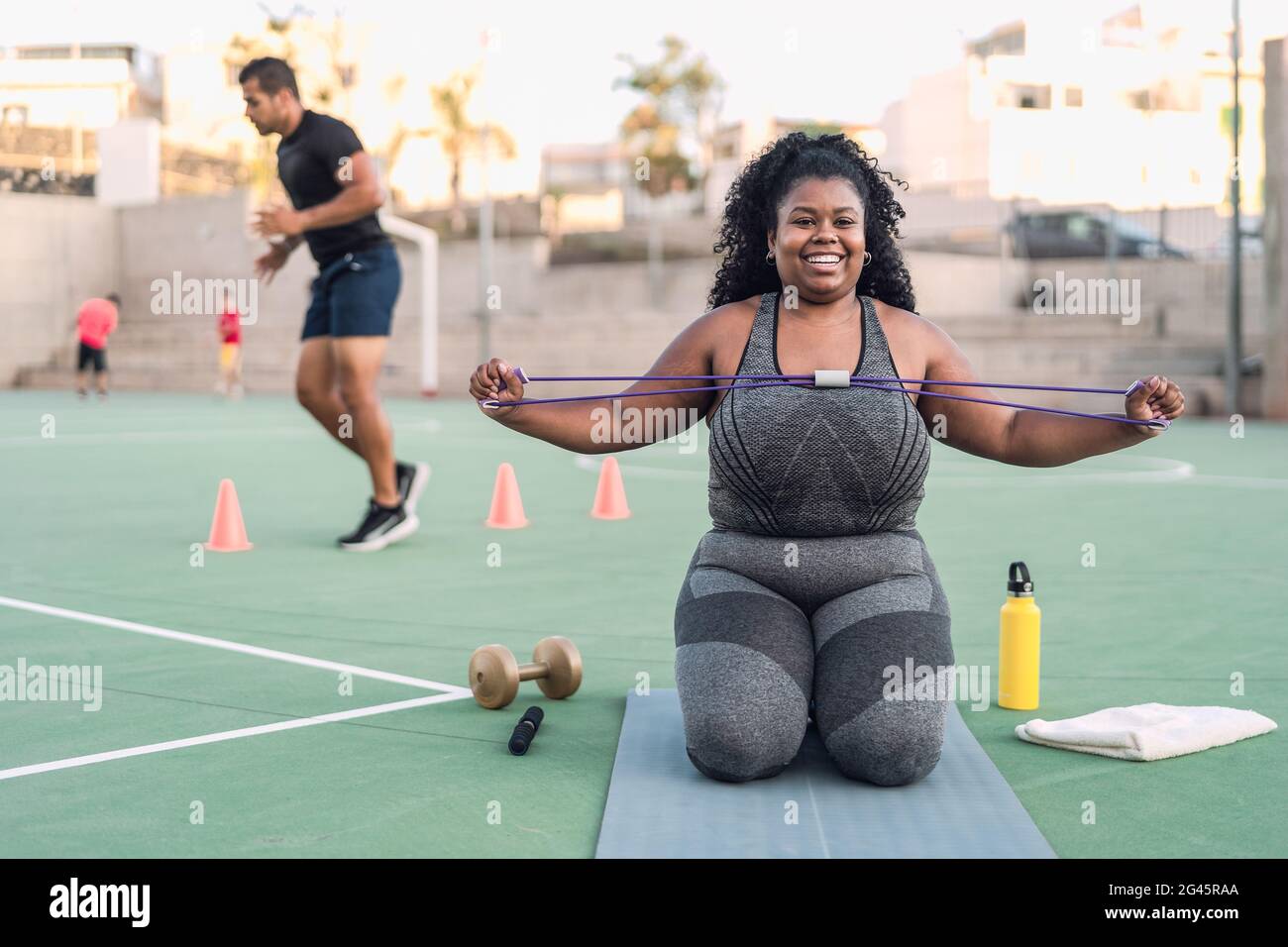 Curvy Afro woman doing workout exercises session - Young African female having fun training outdoor - Sporty people lifestyle concept Stock Photo
