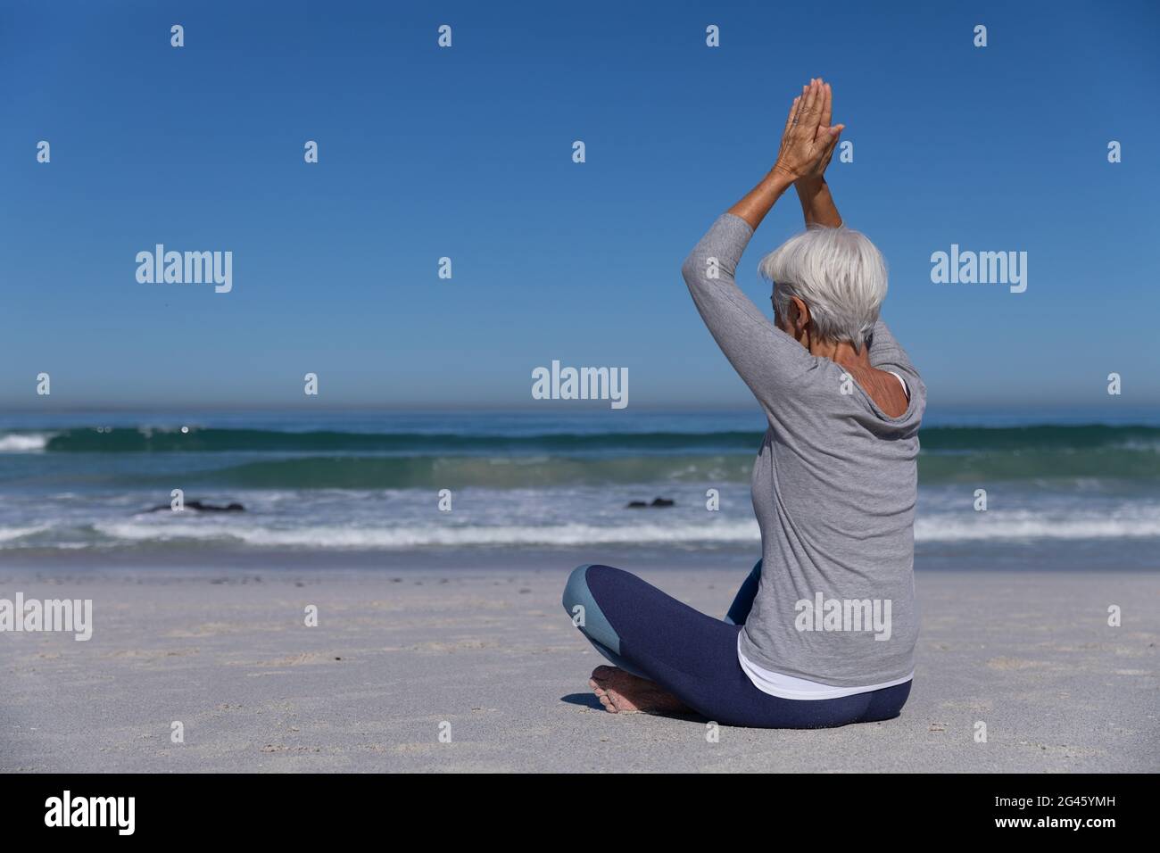 Senior Caucasian woman meditating at the beach Stock Photo - Alamy