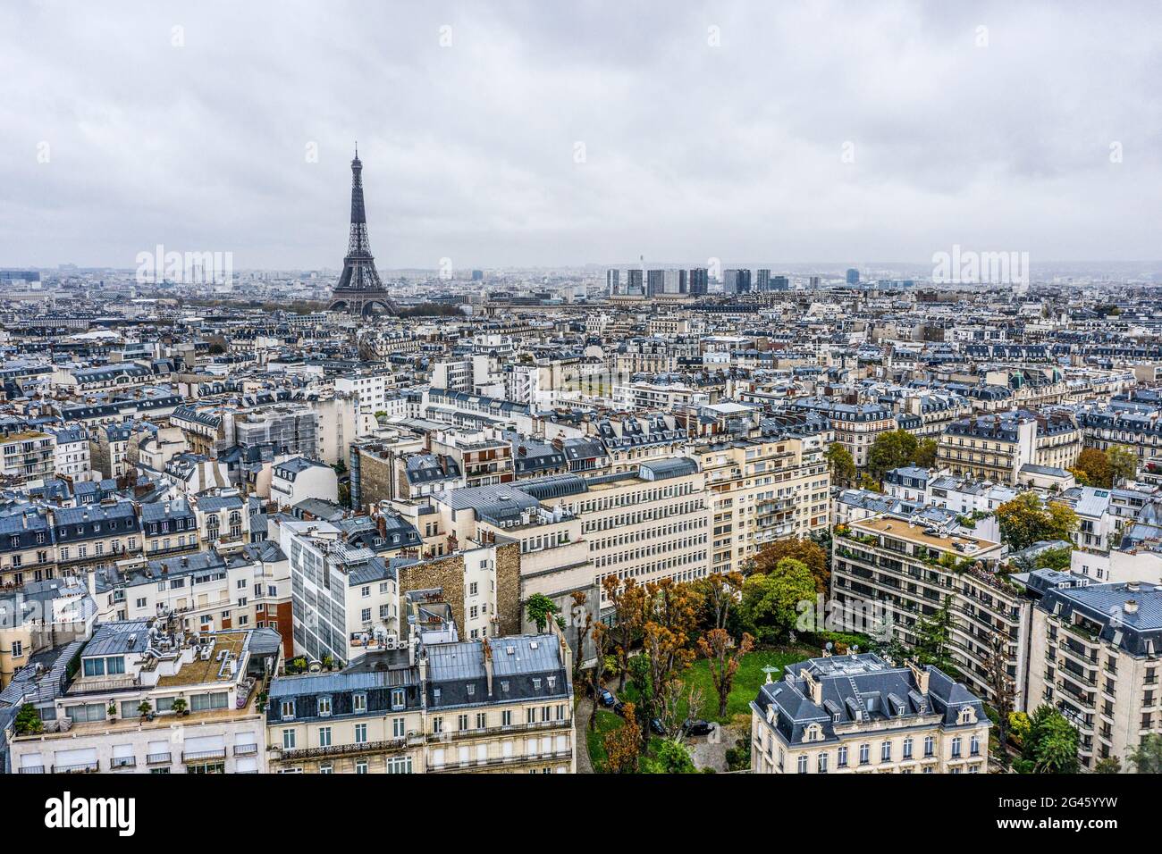 View on Eiffel tower over the roofs of Paris on a grey cloudy day Stock Photo