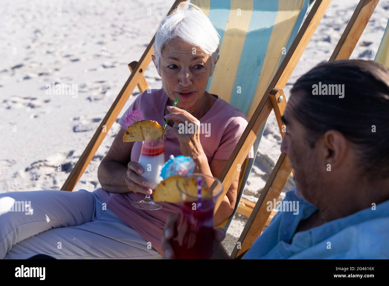 Senior Caucasian couple sitting on deck chairs at the beach Stock Photo ...