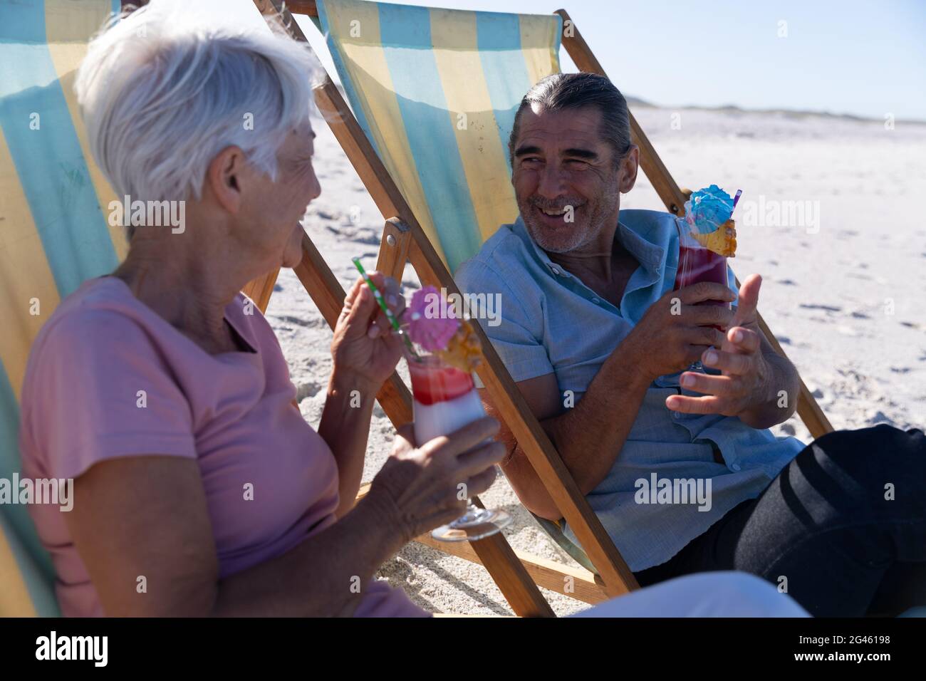 Senior Caucasian couple sitting on deck chairs at the beach Stock Photo ...