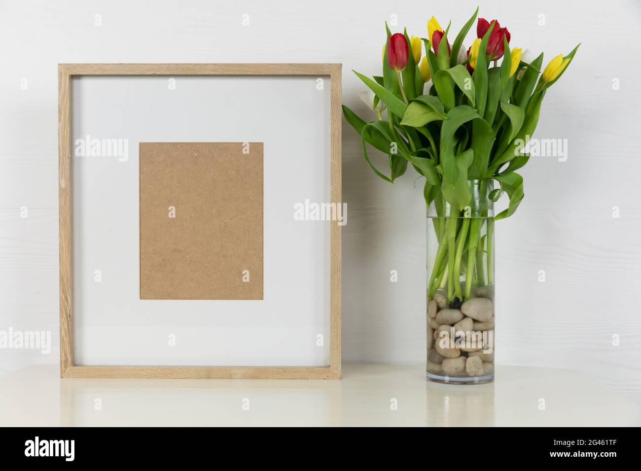 View of a picture frame, with red and yellow tulips placed in a glass ...