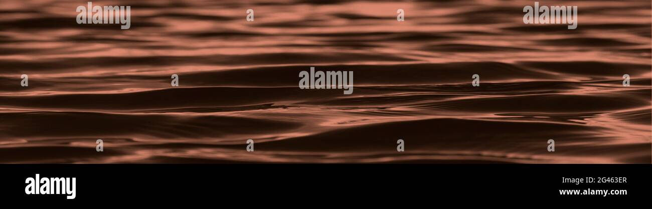 dark brown abstract background. Reflection of light on the smooth surface of water with small waves. Green Tidewater background with copy space for Stock Photo