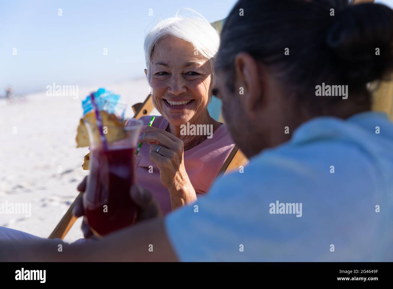 Senior Caucasian couple sitting on deck chairs at the beach Stock Photo ...
