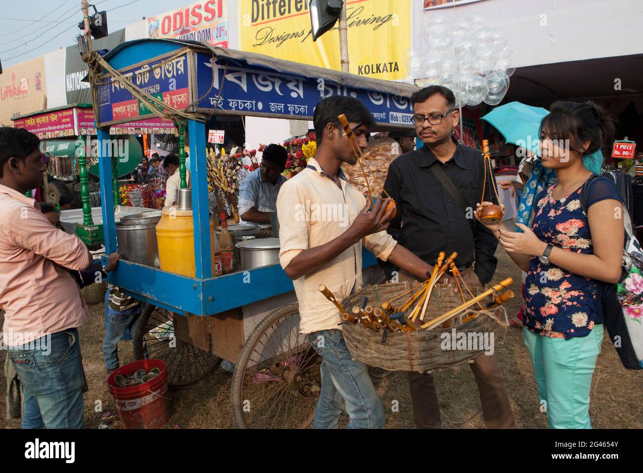 a tribal man selling traditional string music instrument in Poush Mela ...