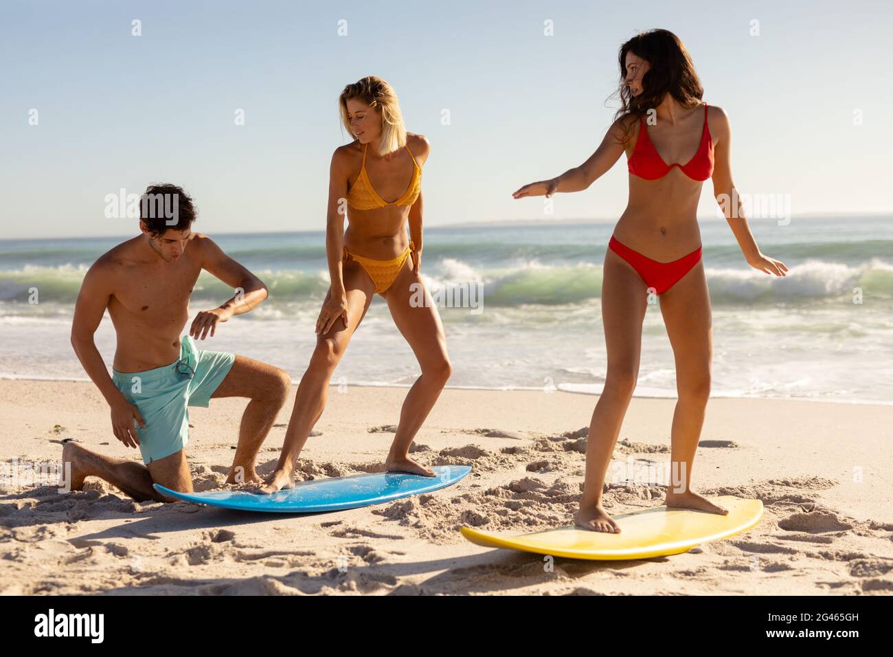 Caucasian group of friends surfing on the beach Stock Photo