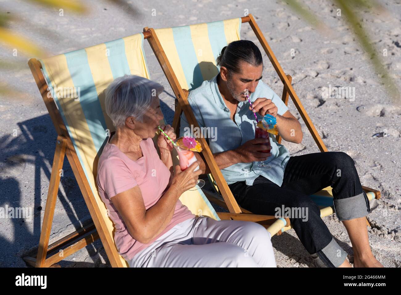 Senior Caucasian couple sitting on deck chairs at the beach Stock Photo ...
