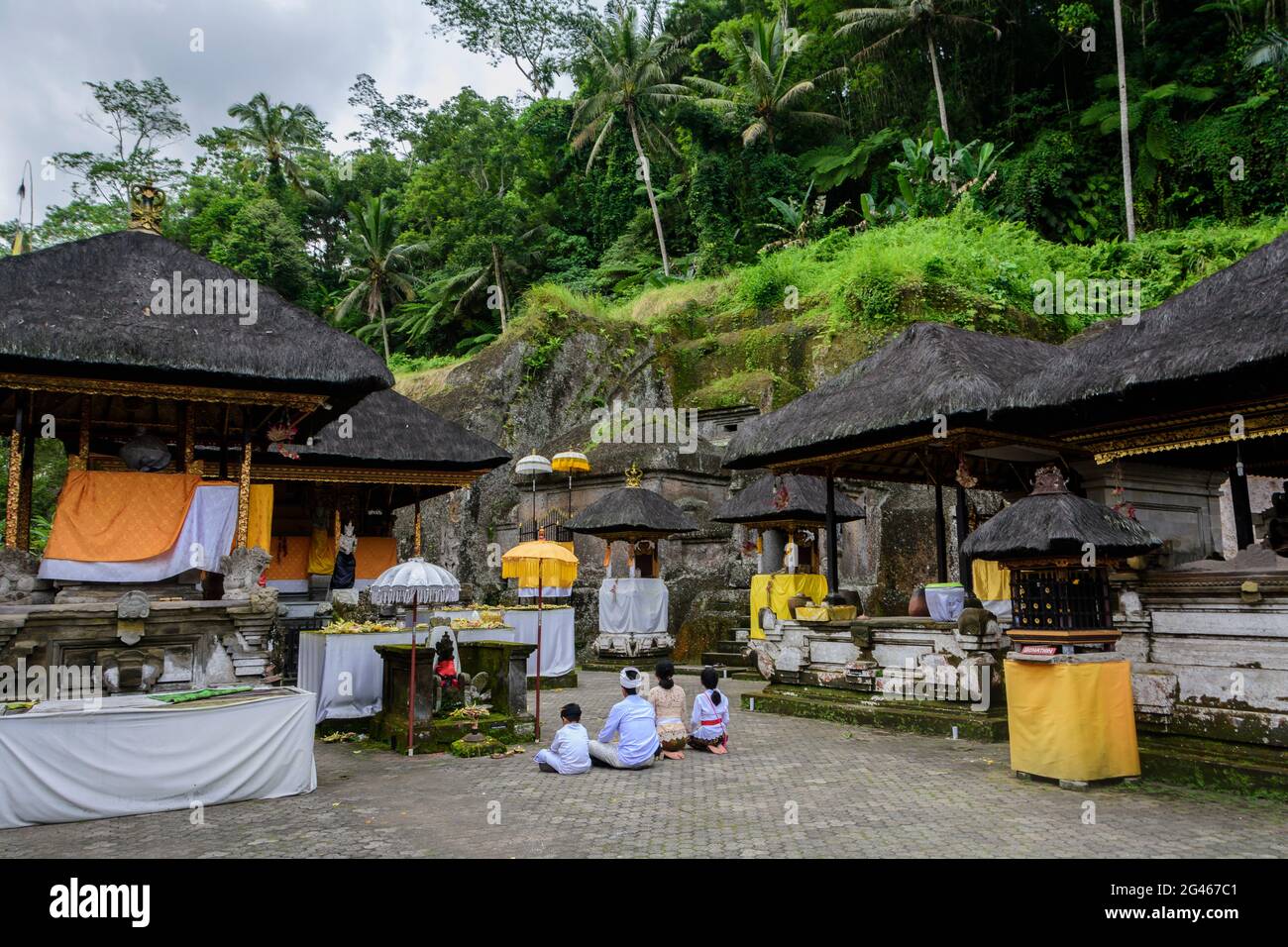 Worshippers performing a puja at the Gunung Kawi temple and funerary complex near Tampaksiring, Bali, Gianyar Regency, Indonesia Stock Photo