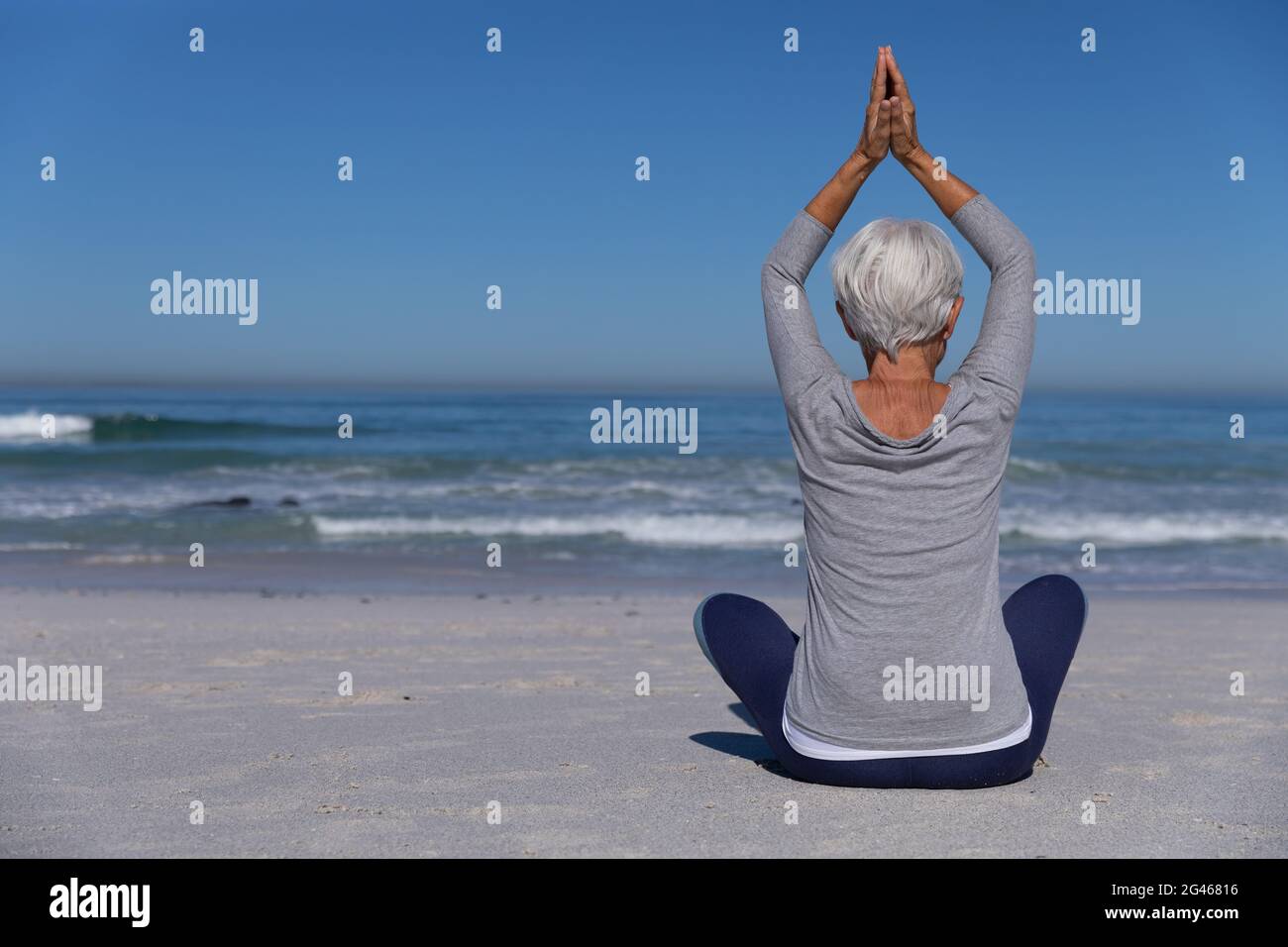 Senior Caucasian woman meditating at the beach Stock Photo - Alamy