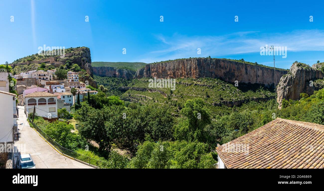 Landscape of rocky cliffs covered in greenery surrounded by buildings ...