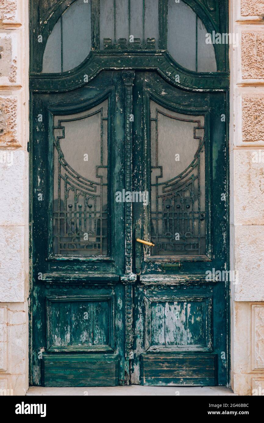 Green doors. Wood texture. Old shabby, irradiated paint. Stock Photo
