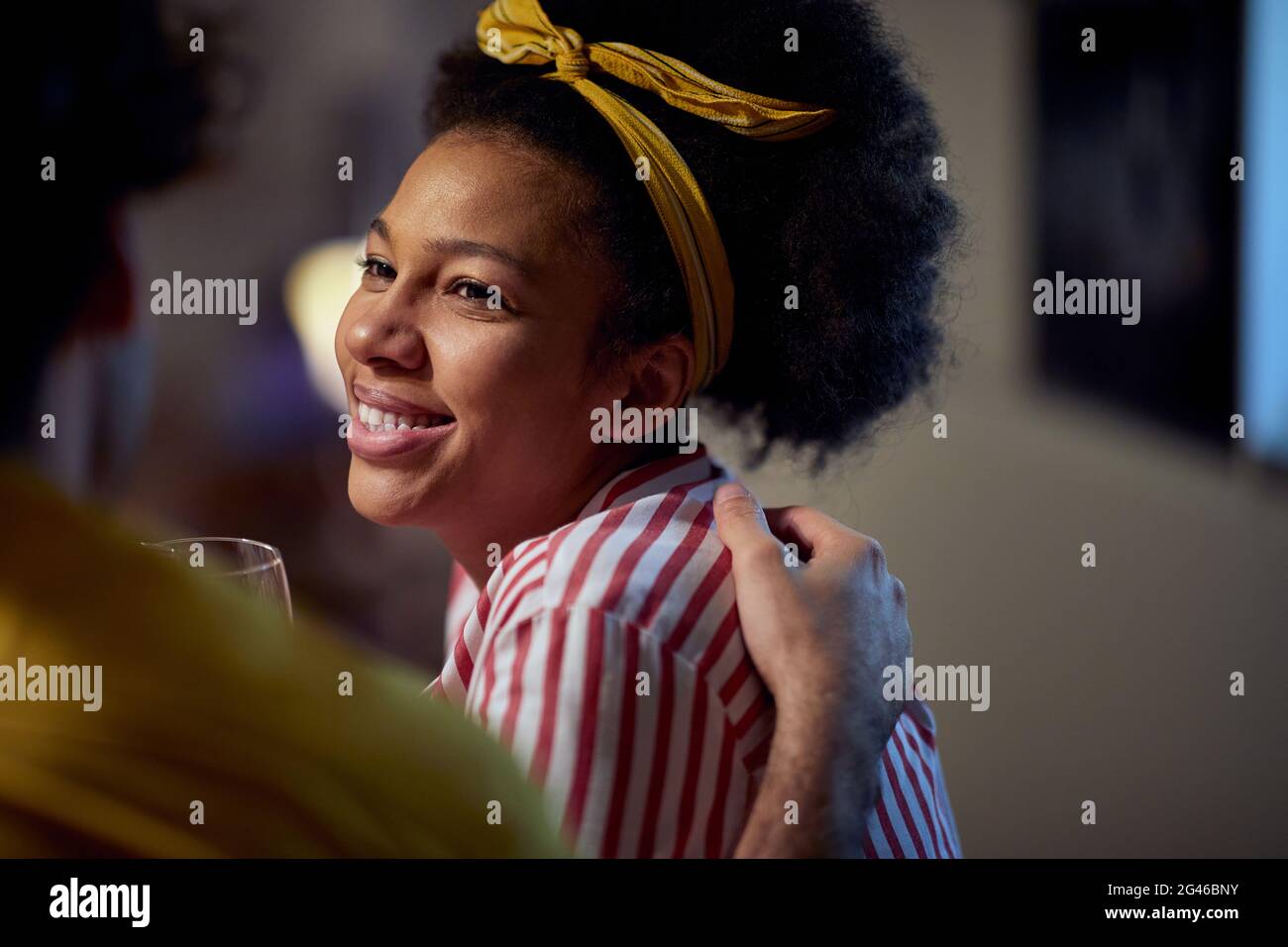 young afro-american female hugged by a caucasian male, enjoying the friendship, looking at him Stock Photo