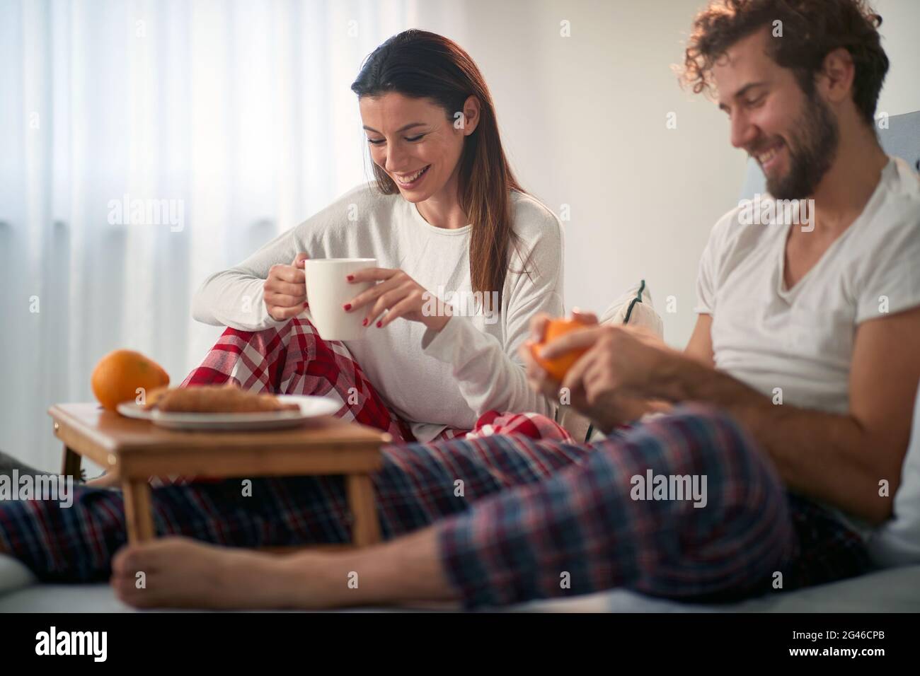 A young couple in love having breakfast in the bed at their bedroom. Love, relationship, together Stock Photo