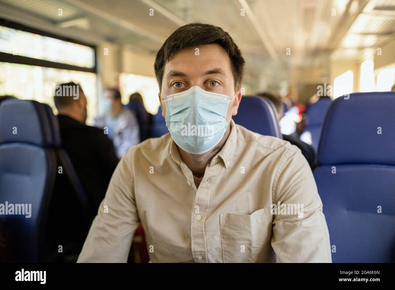 Male passenger wearing face mask during covid-19 lockdown inside train. New normal lifestyle concept. Social distancing when tra Stock Photo