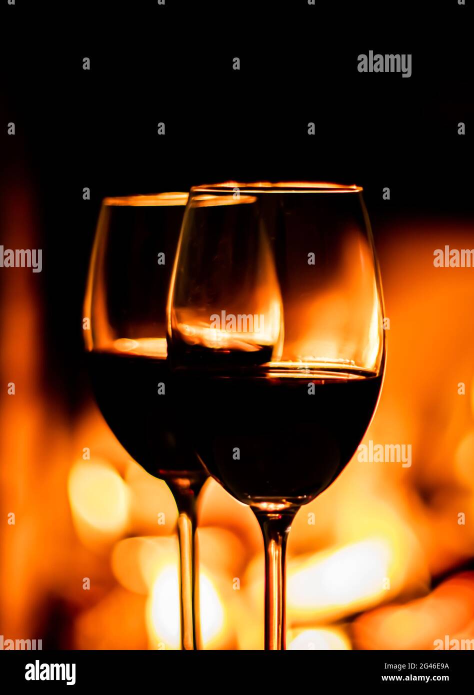 Two glasses of red wine on the background of fireplace lights Stock Photo