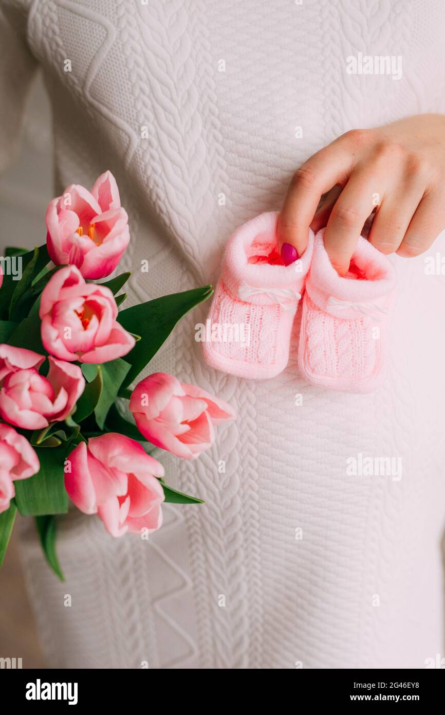 Belly of a pregnant girl and tulips in hands Stock Photo