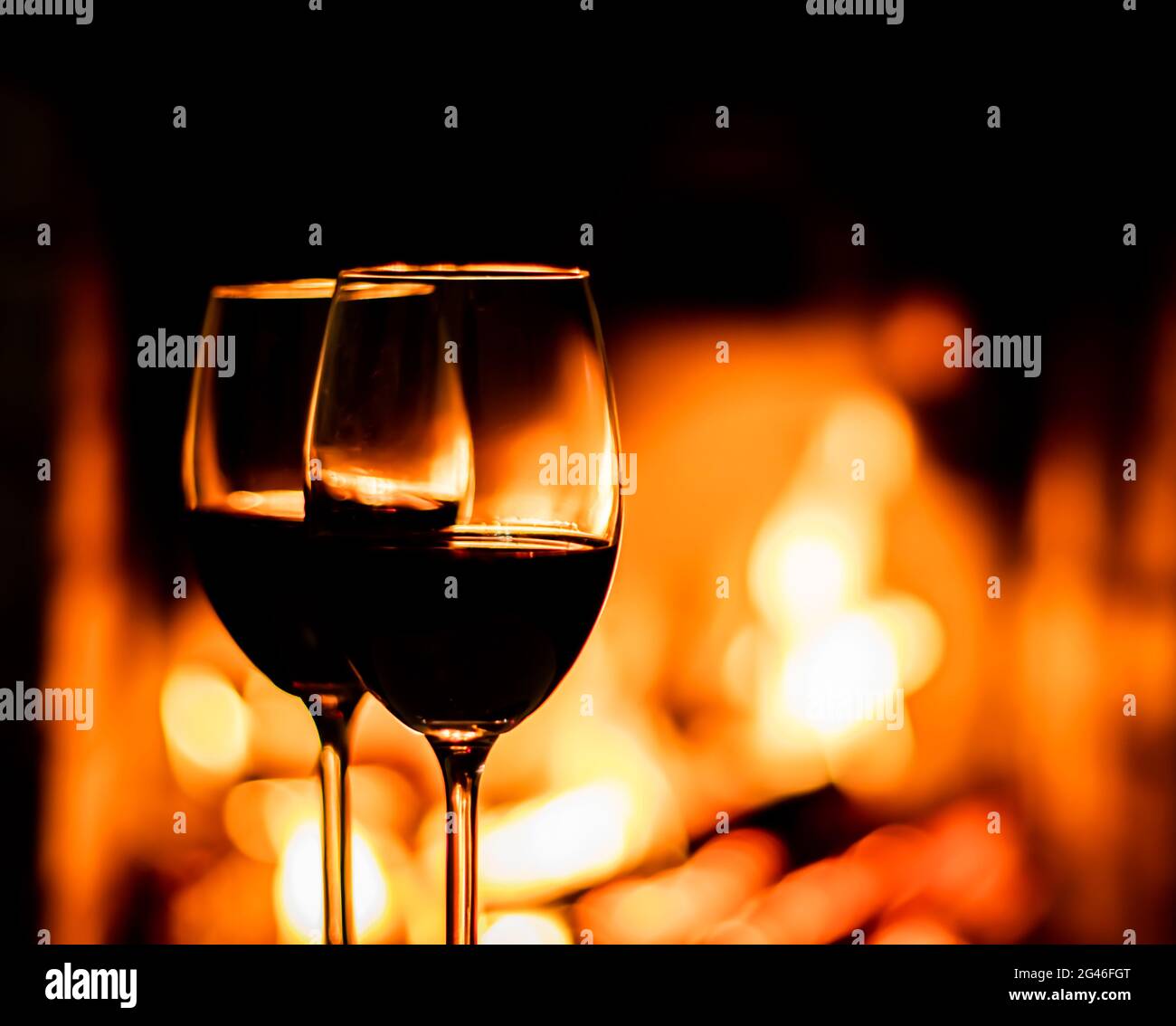 Two glasses of red wine on the background of fireplace lights Stock Photo