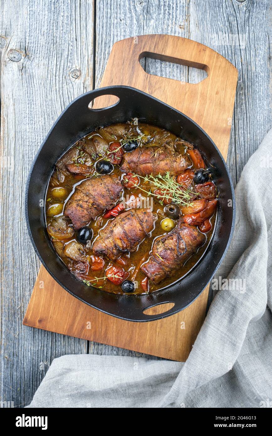 Modern style traditional slow cooked German beef roulades with vegetable and olives in spicy gravy sauce offered as top view in Stock Photo