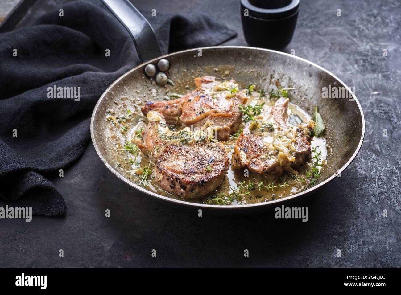 Traditional barbecue dry aged veal chops with herbs in butter jus