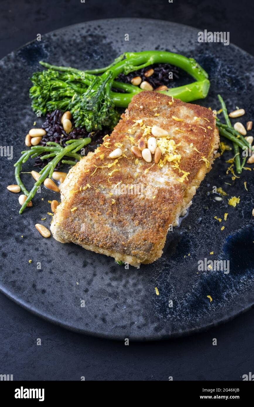 Modern style traditional panfried skrei cod fish filet in breadcrumbs with baby broccoli Stock