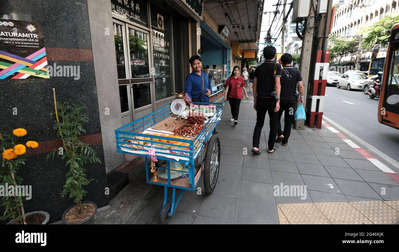 Man Selling Fruit Food with a Push Cart on Walk Way in Bangkok Thailand day Stock Photo