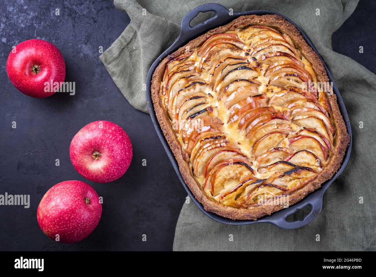 Traditional French apple tarte offered as top view on a design cast iron pan Stock Photo